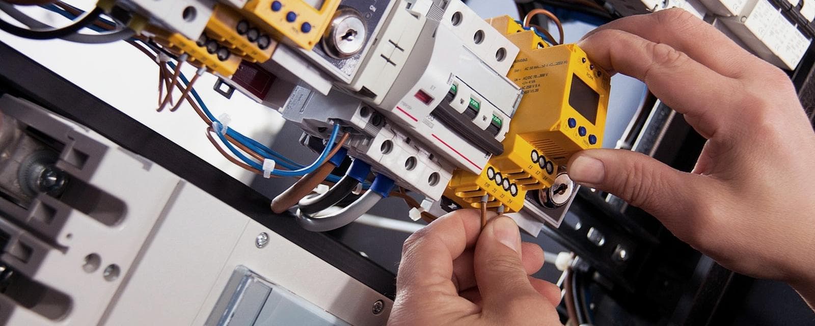 Technicien contrôlant un tableau électrique selon la norme NF C 15-100